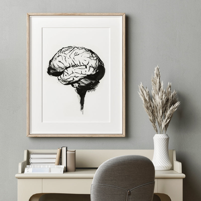 Doctor's office art. It's framed artwork of black and white brain anatomy painting art on a wall above a desk with a vase of dried plants.