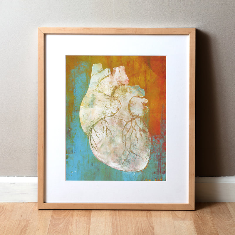 Framed artwork showing abstract anatomy art. The anatomy painting is made of oil and cold wax and shows a white anatomical heart on a teal and orange background. Great for a doctor's office or medical clinic gift.