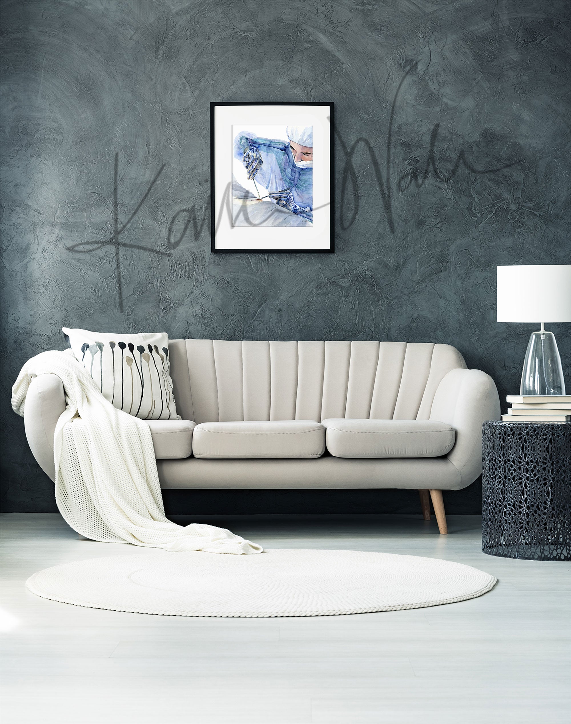 Framed watercolor painting showing the ergonomics of a surgeon at work. The painting is hanging over a white couch.