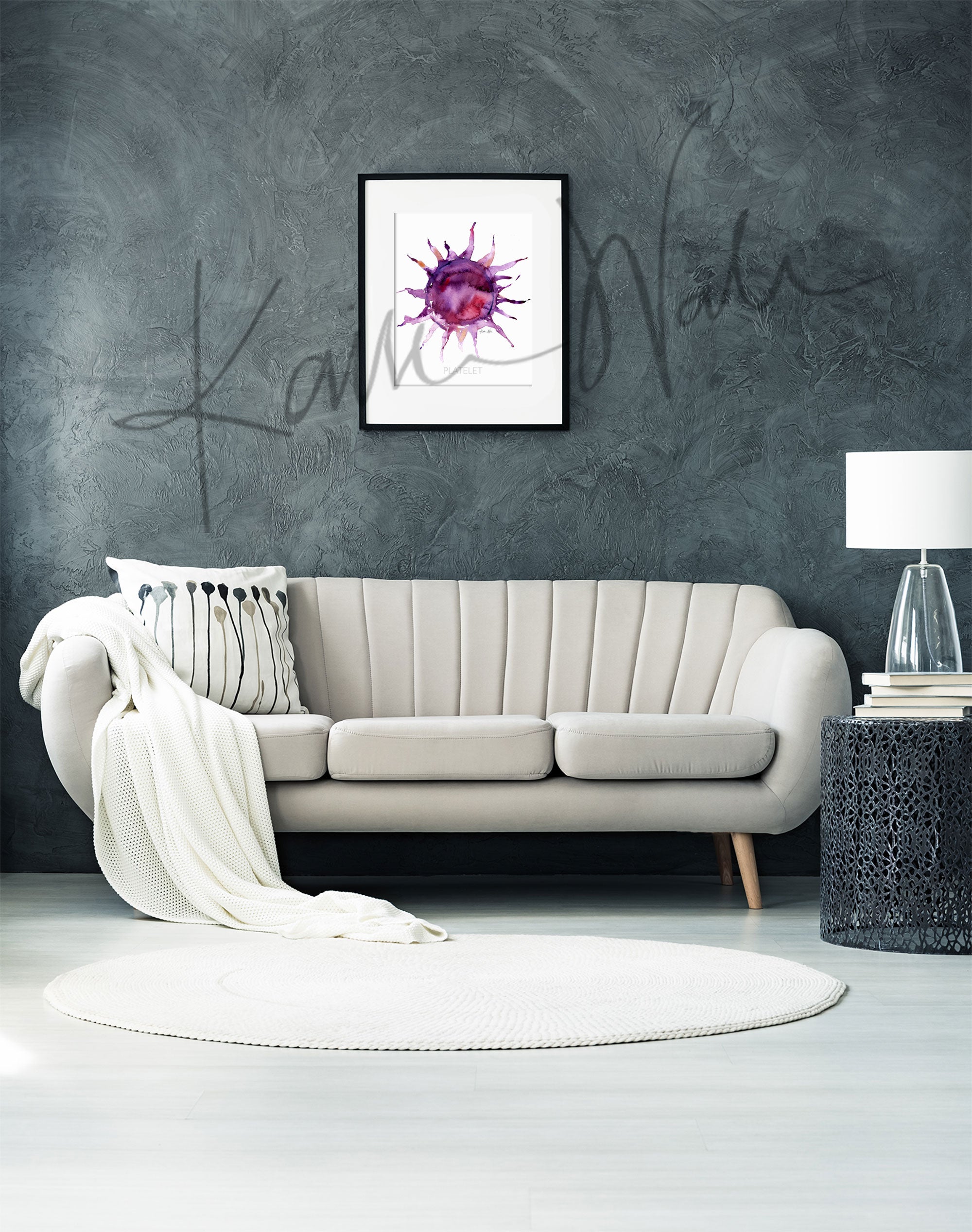 Framed watercolor painting of a platelet. The painting is hanging over a white couch.